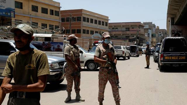 Paramilitary soldiers stand guard after a grenade blast outside a college, in Karachi