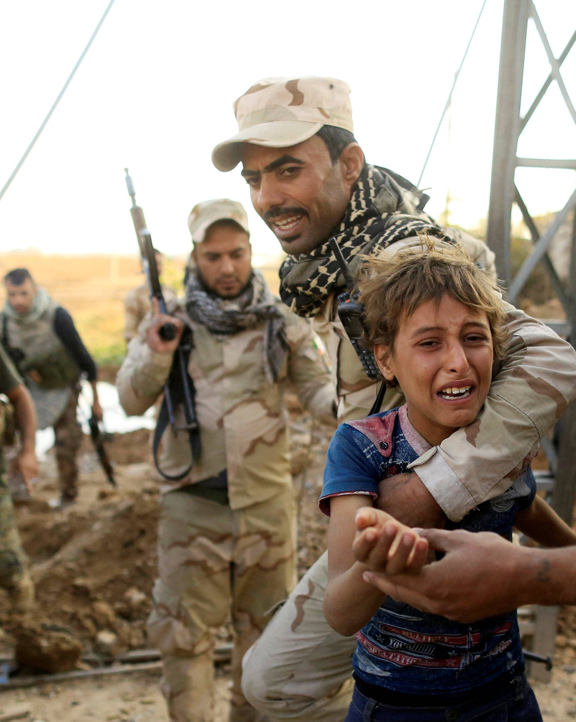 A boy reacts as Iraqi soldiers help him to walk out the front line during a battle with Islamic State in the Intisar disrict of eastern Mosul