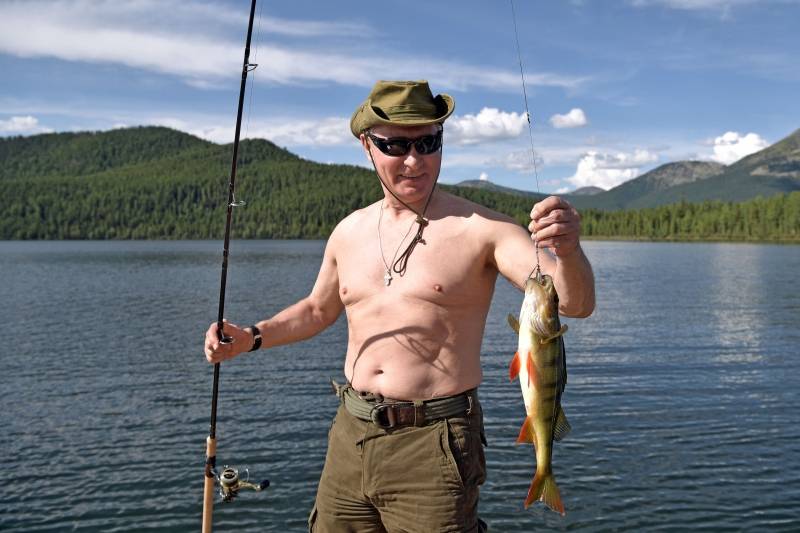 Russian President Vladimir Putin holds a fish he caught during the hunting and fishing trip which took place on August 1-3 in the republic of Tyva in southern Siberia