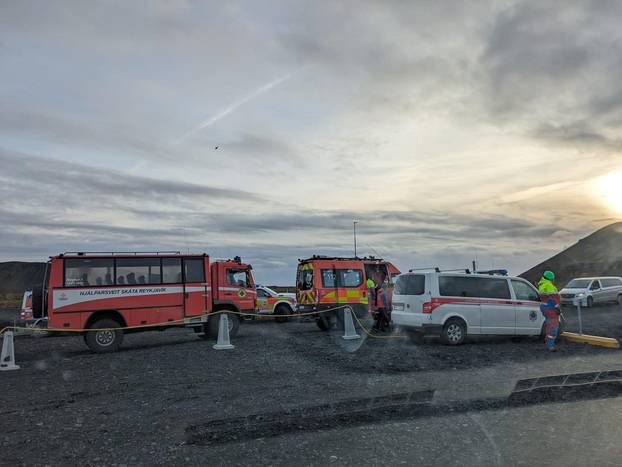 Emergency vehicles are parked on a road due to volcanic activity near Grindavik