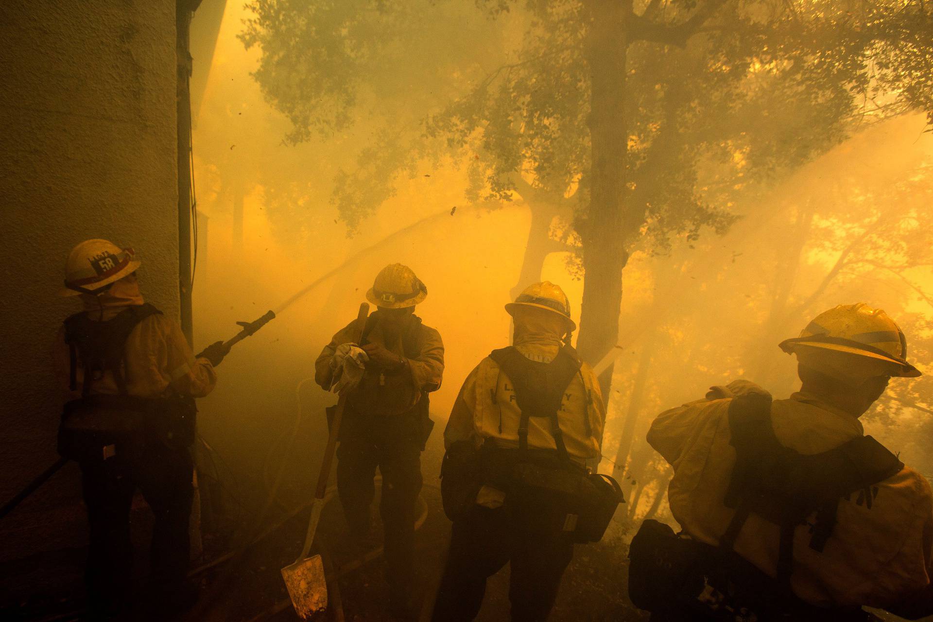 Firefighters battle a wildfire near a structure while defending the Mount Wilson observatory during the Bobcat Fire in Los Angeles