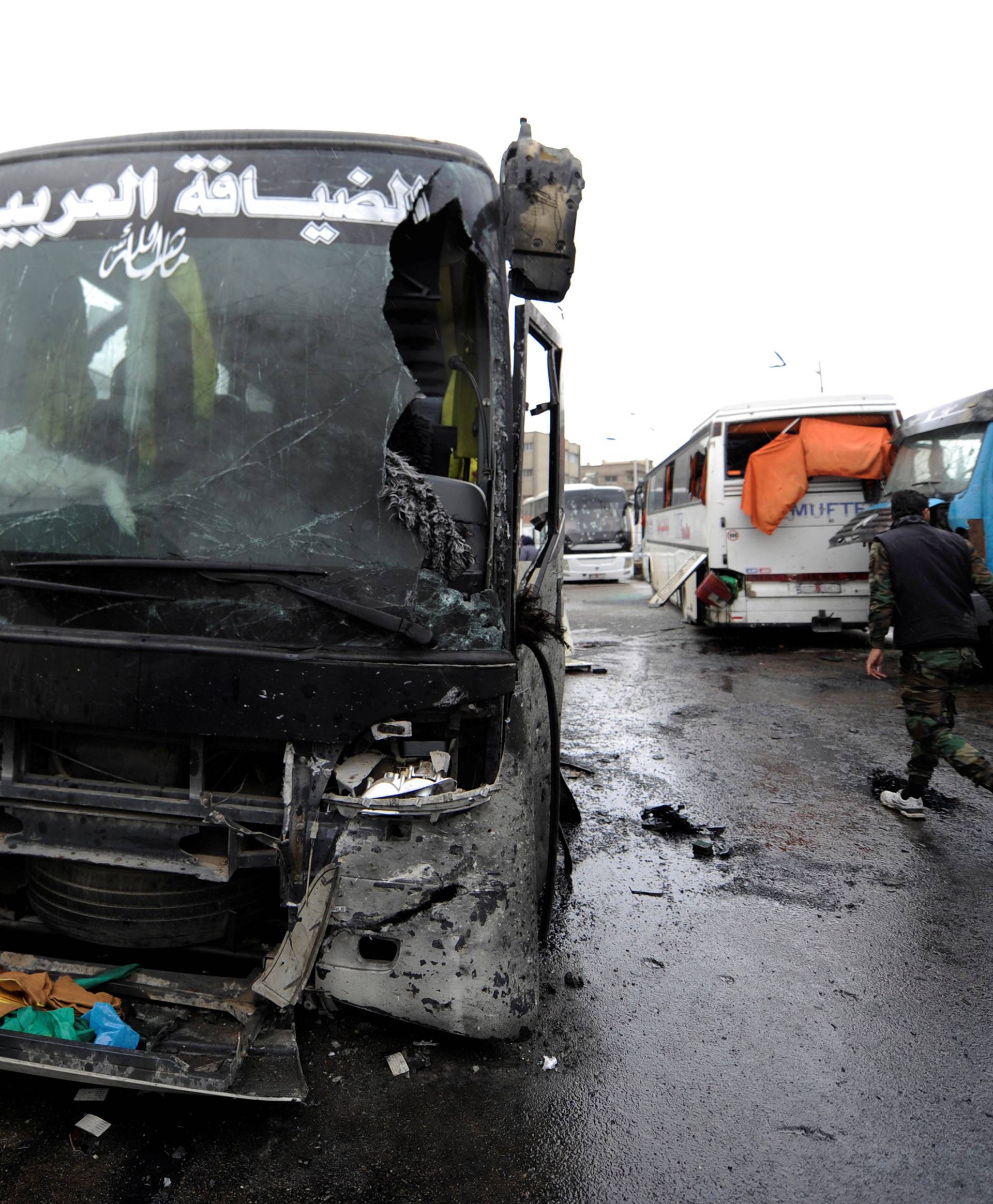 Damaged buses are pictured at the site of an attack by two suicide bombers in Damascus