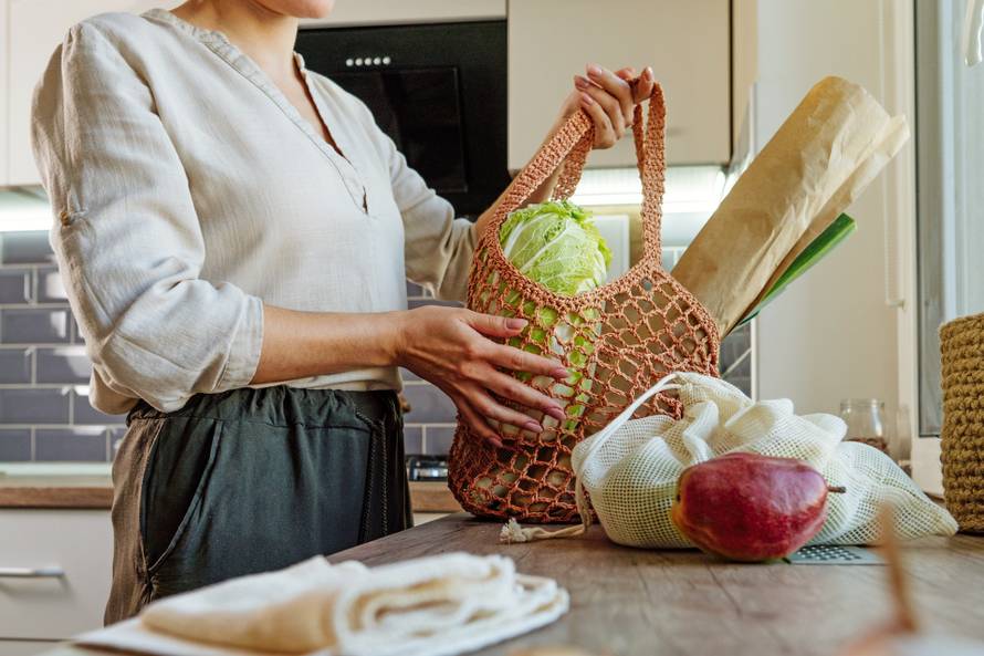 Young,Woman,Holding,Reusable,Mesh,Bag,With,Fruits,,Vegetables,And