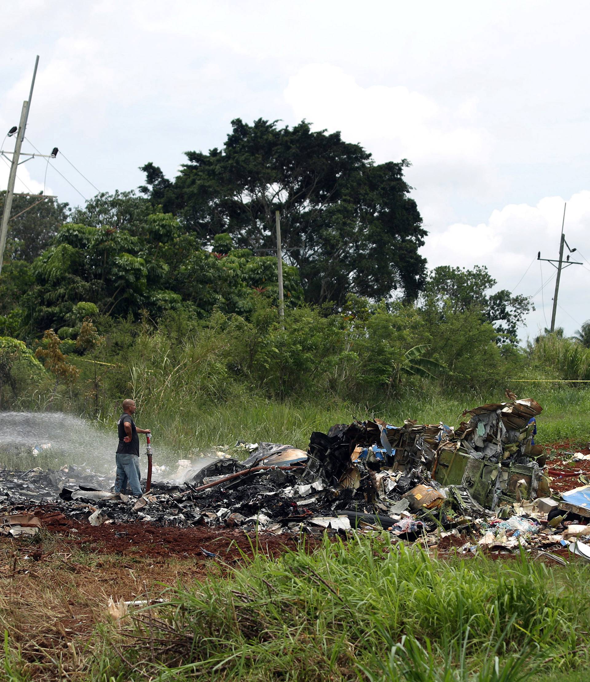 Rescue team members work in the wreckage of a Boeing 737 plane that crashed in the agricultural area of Boyeros