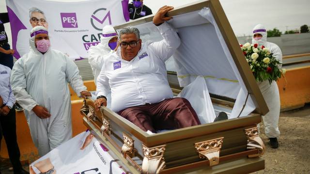 Carlos Mayorga, Mexican candidate for federal representative, emerges from a coffin as part of his campaign slogan "If I don't deliver, let them bury me alive" near the Zaragoza-Ysleta international border bridge, in Ciudad Juarez