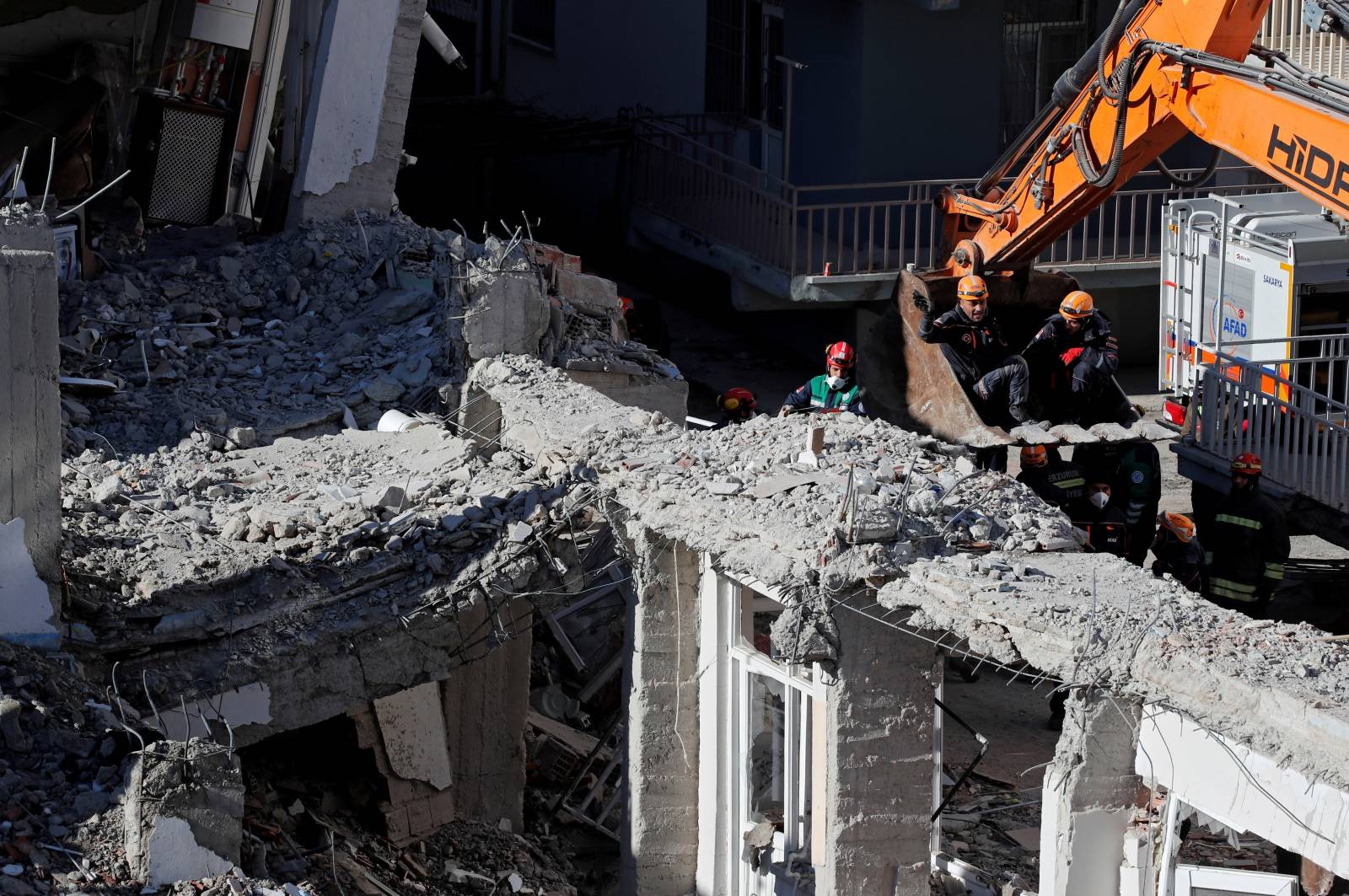 Rescue workers search the site of a collapsed building, after an earthquake in Elazig