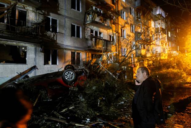 Firefighters work at the site of an apartment building hit by a Russian missile strike in Kyiv