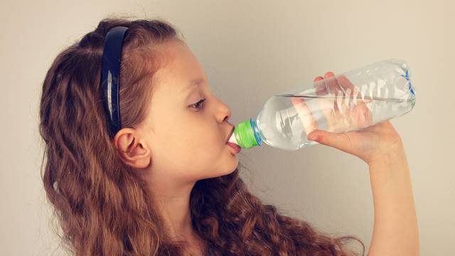 Profile of beautiful long curly hair style smiling kid girl drin