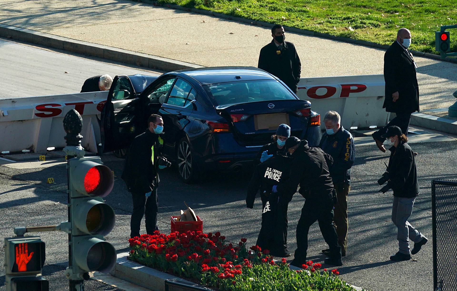 Law enforcement officers hold up a U.S. Capitol Police jacket at the site after a car rammed a police barricade outside the U.S. Capitol building on Capitol Hill in Washington