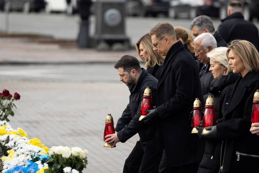 Ukraine's President Zelenskiy his wife Olena and foreign leader visit a makeshift memorial to fallen Ukrainian defenders at the Independent Square on the fourth anniversary of Russia's full-scale invasion, in Kyiv