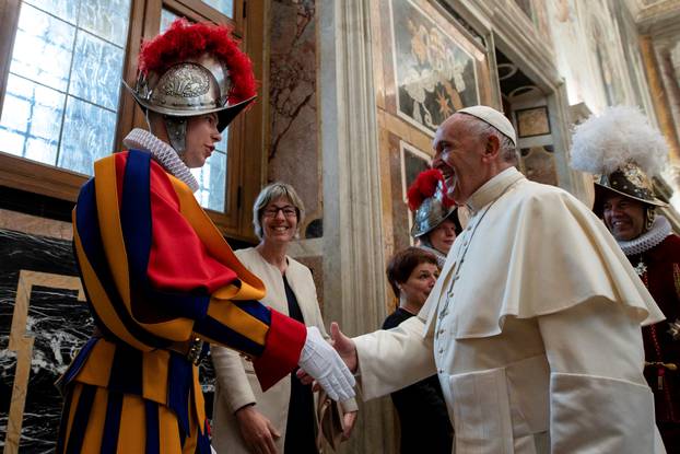 Pope Francis shakes hands with a Swiss guard the day ahead of their swearing-in ceremony at the Vatican