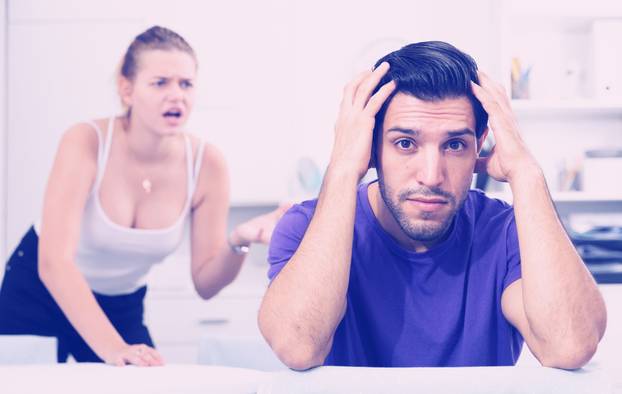 Upset man at table with disgruntled woman behind 