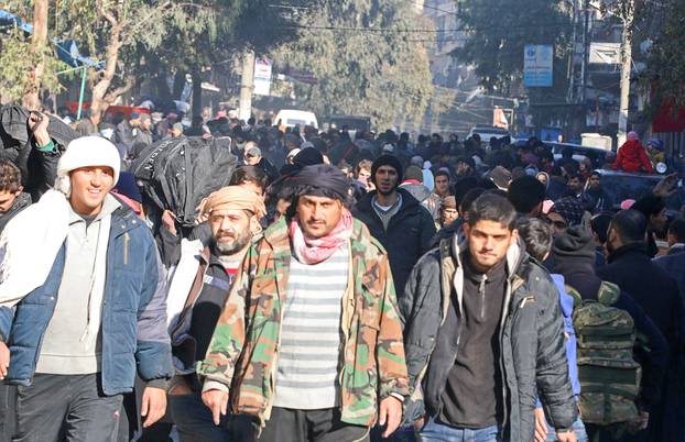 People gather to be evacuated from a rebel-held sector of eastern Aleppo