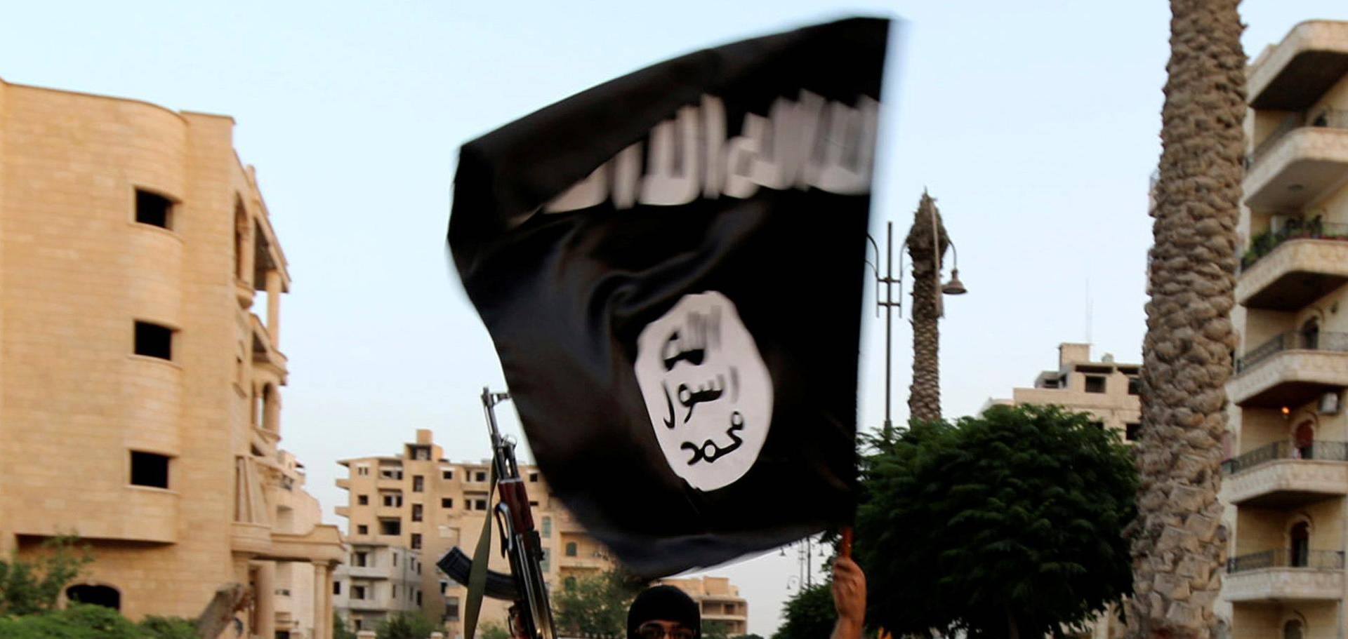 FILE PHOTO: A member loyal to the ISIL waves an ISIL flag in Raqqa