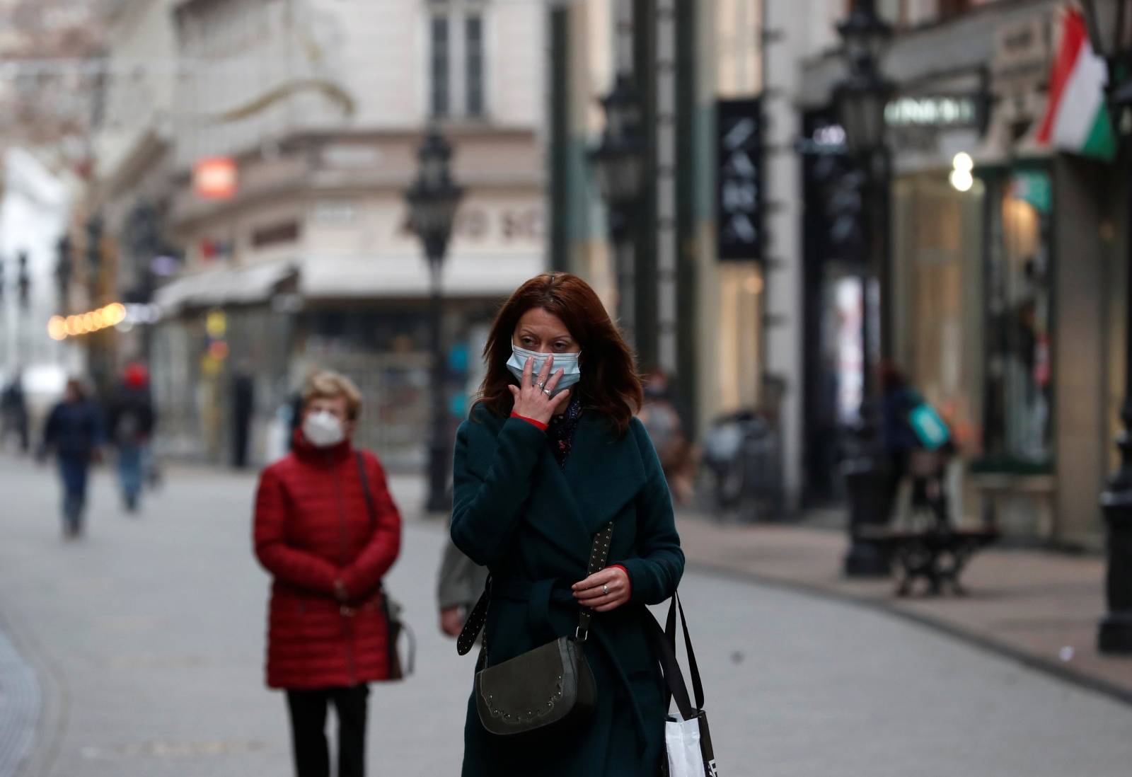 People wearing protective face masks walk in downtown Budapest