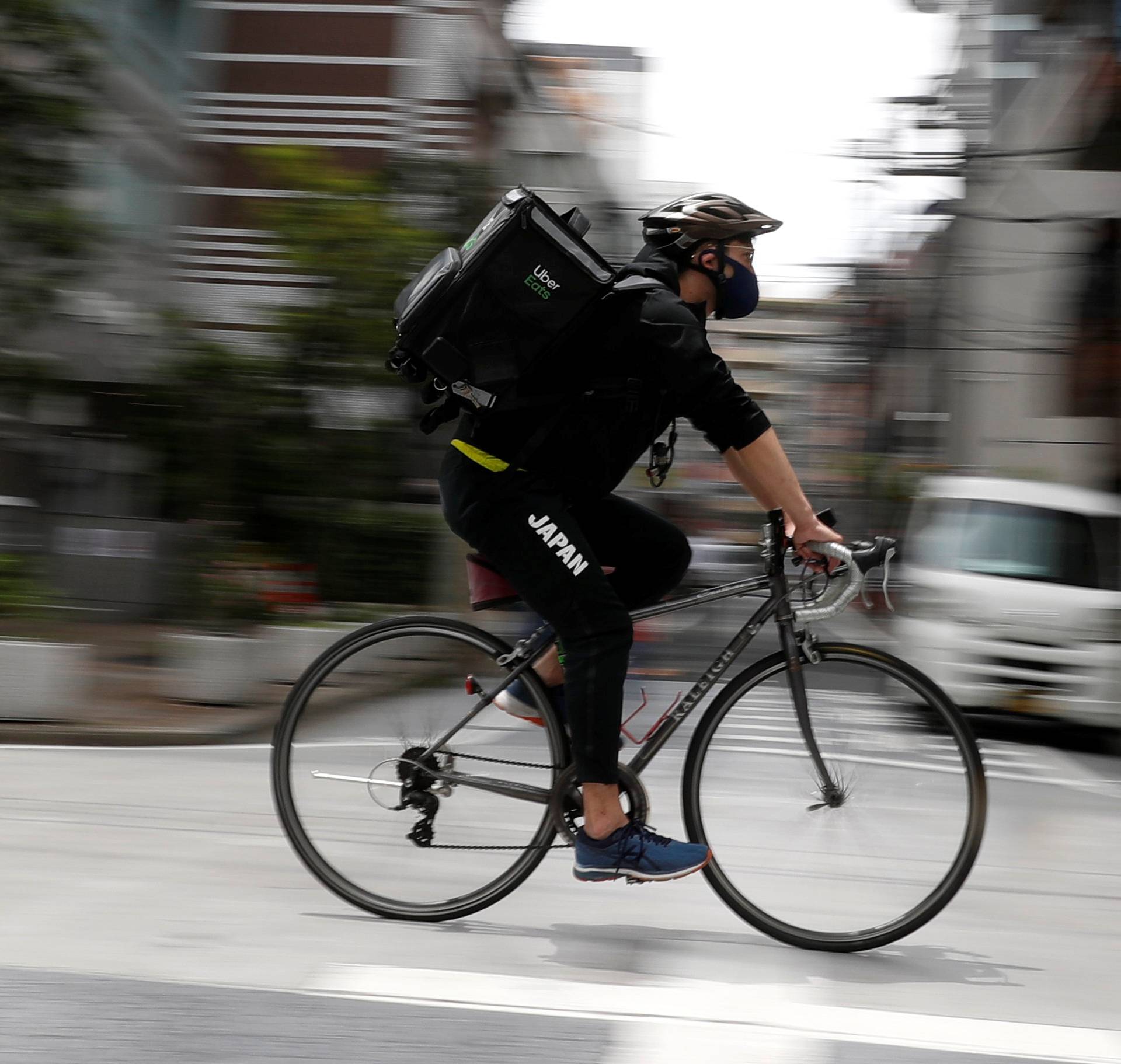 Japan's Olympic fencing medallist Ryo Miyake cycles as he works his part-time job as Uber Eats delivery person as the spread of the coronavirus disease (COVID-19) continues in Tokyo