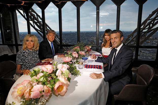 Brigitte Macron, wife of French President Emmanuel Macron, U.S. President Donald Trump and First lady Melania Trump pose at their table at the Jules Verne restaurant for a private dinner at the Eiffel Tower in Paris