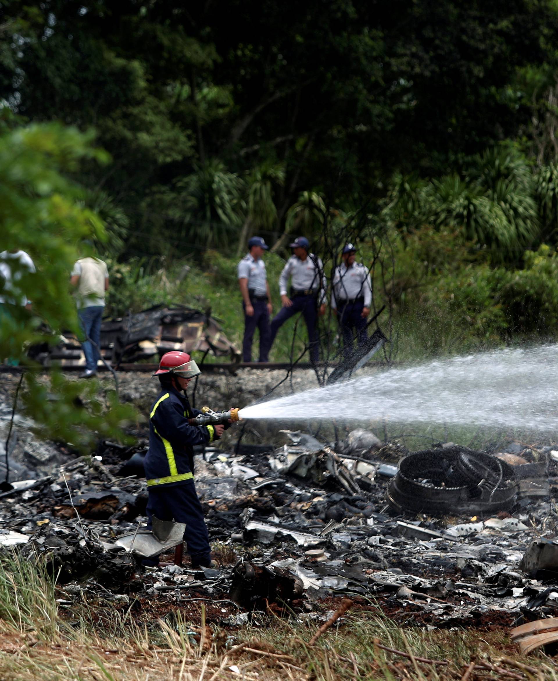 Firefighters work in the wreckage of a Boeing 737 plane that crashed in the agricultural area of Boyeros