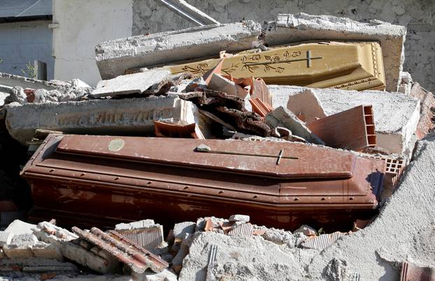 Coffins covered by debris are seen in a cemetery following an earthquake at Sant