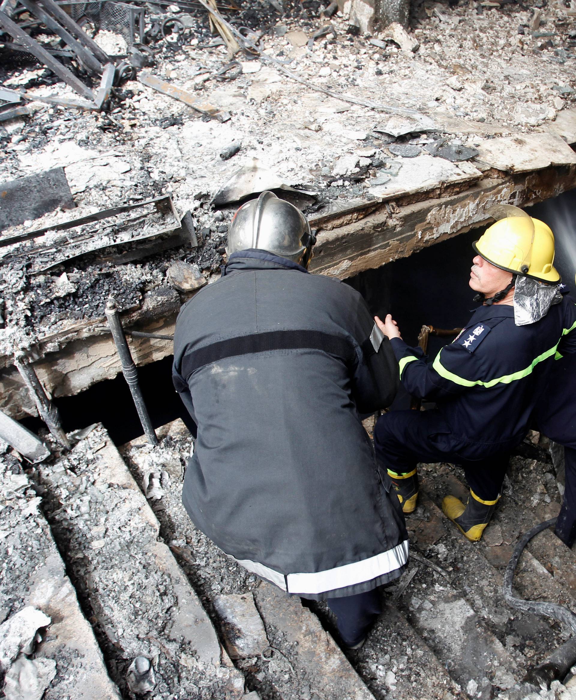 Firemen hose down a burning building after a suicide car bomb occurred in the Karrada shopping area in Baghdad, Iraq