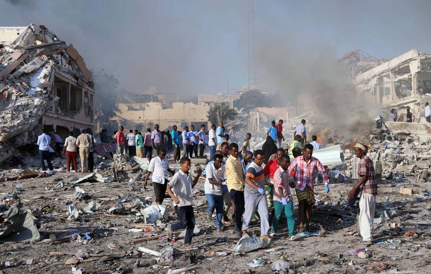 Civilians carry the dead body of unidentified man from the scene of explosion in Mogadishu