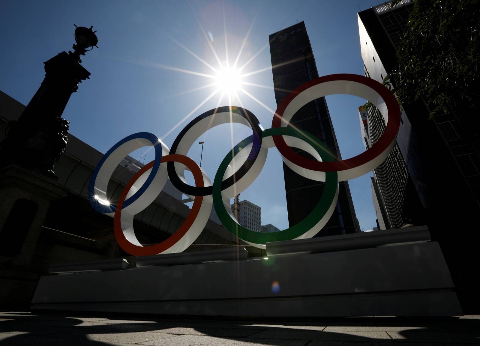 Summer sunshine is seen through Olympic rings displayed at Nihonbashi district in Tokyo, Japan