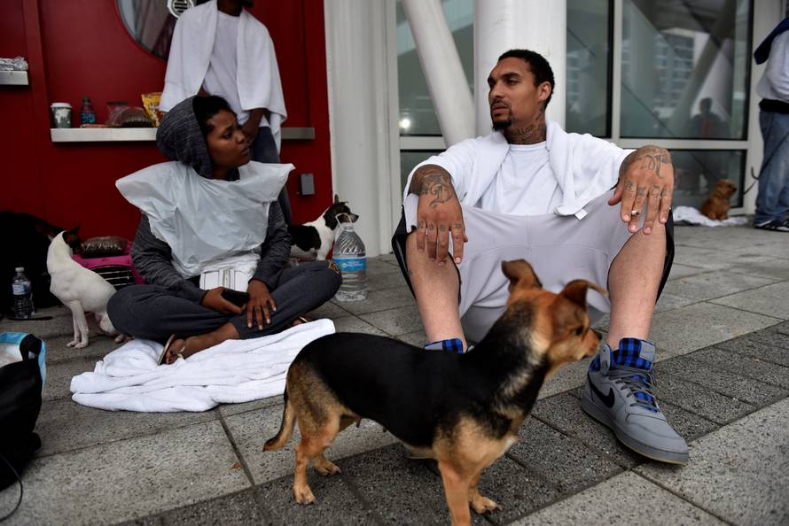 Evacuees Danielle White and her husband Lorenzo White wait to get into of the George R. Brown Convention Center after Hurricane Harvey inundated the Texas Gulf coast with rain causing widespread flooding