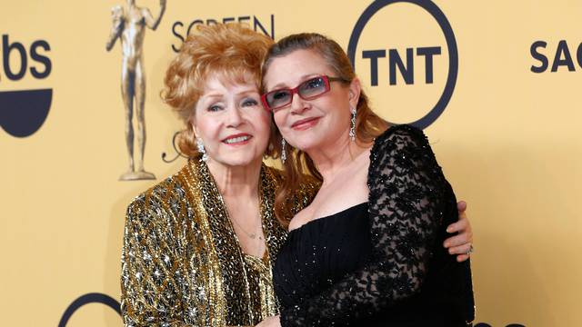 FILE PHOTO: Actress Debbie Reynolds poses with her daughter actress Carrie Fisher backstage after accepting her Lifetime Achievement award at the 21st annual Screen Actors Guild Awards in Los Angeles