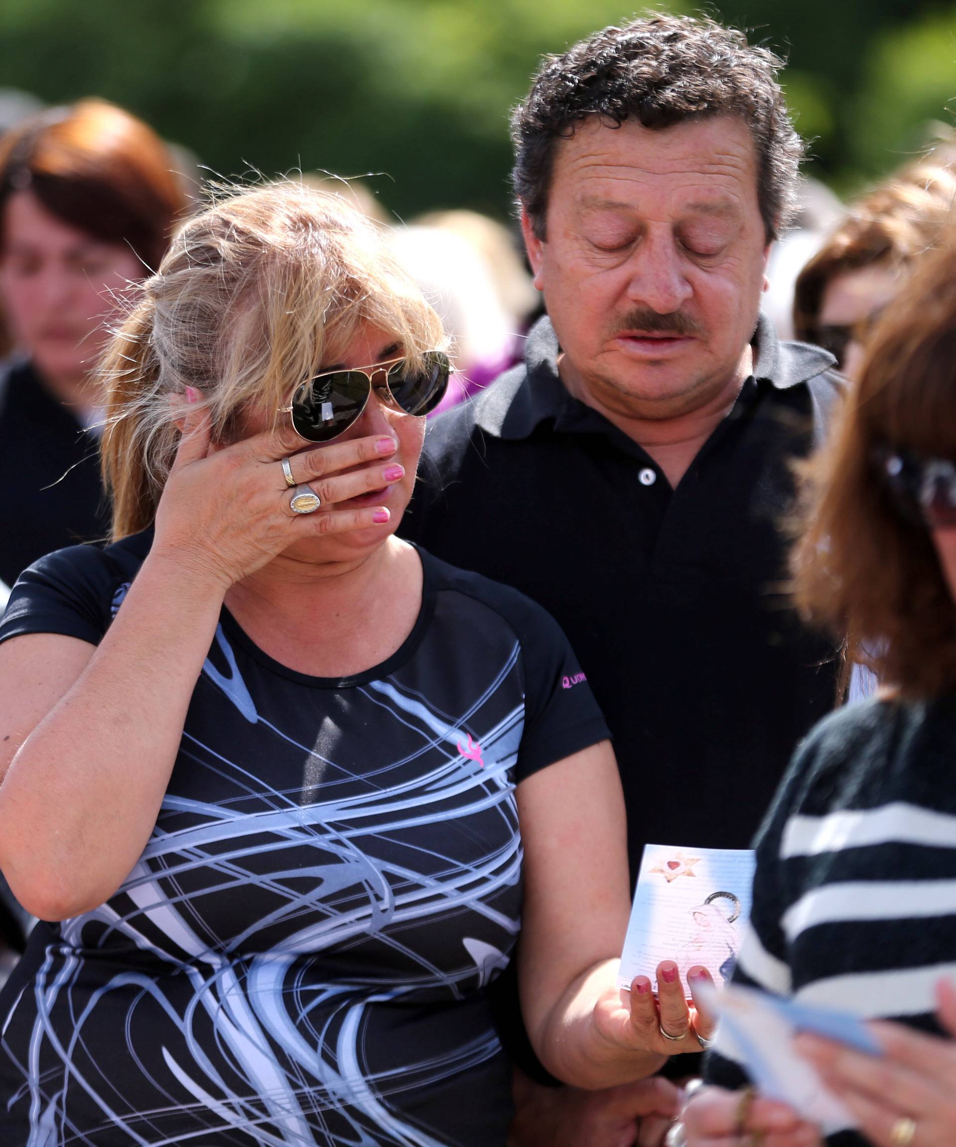 A woman reacts as people gather to pray for the 44 crew members of the missing at sea ARA San Juan submarine, at the entrance of an Argentine Naval Base in Mar del Plata