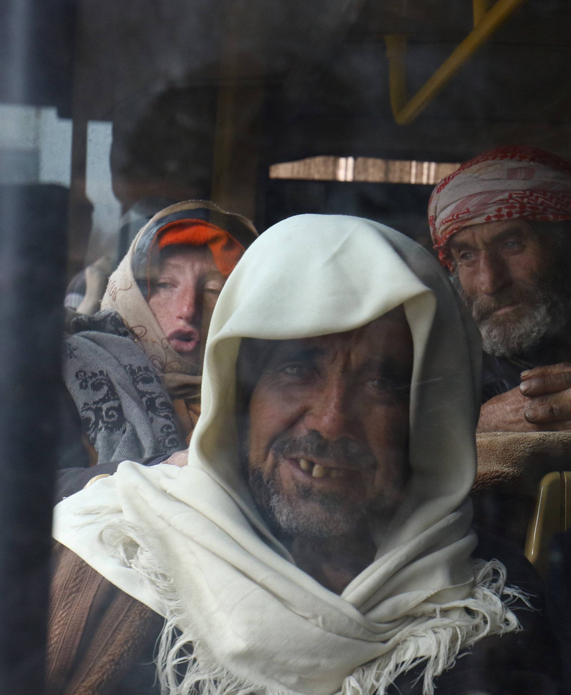 Evacuees from the Shi'ite Muslim villages of al-Foua and Kefraya ride a bus at insurgent-held al-Rashideen in Aleppo province