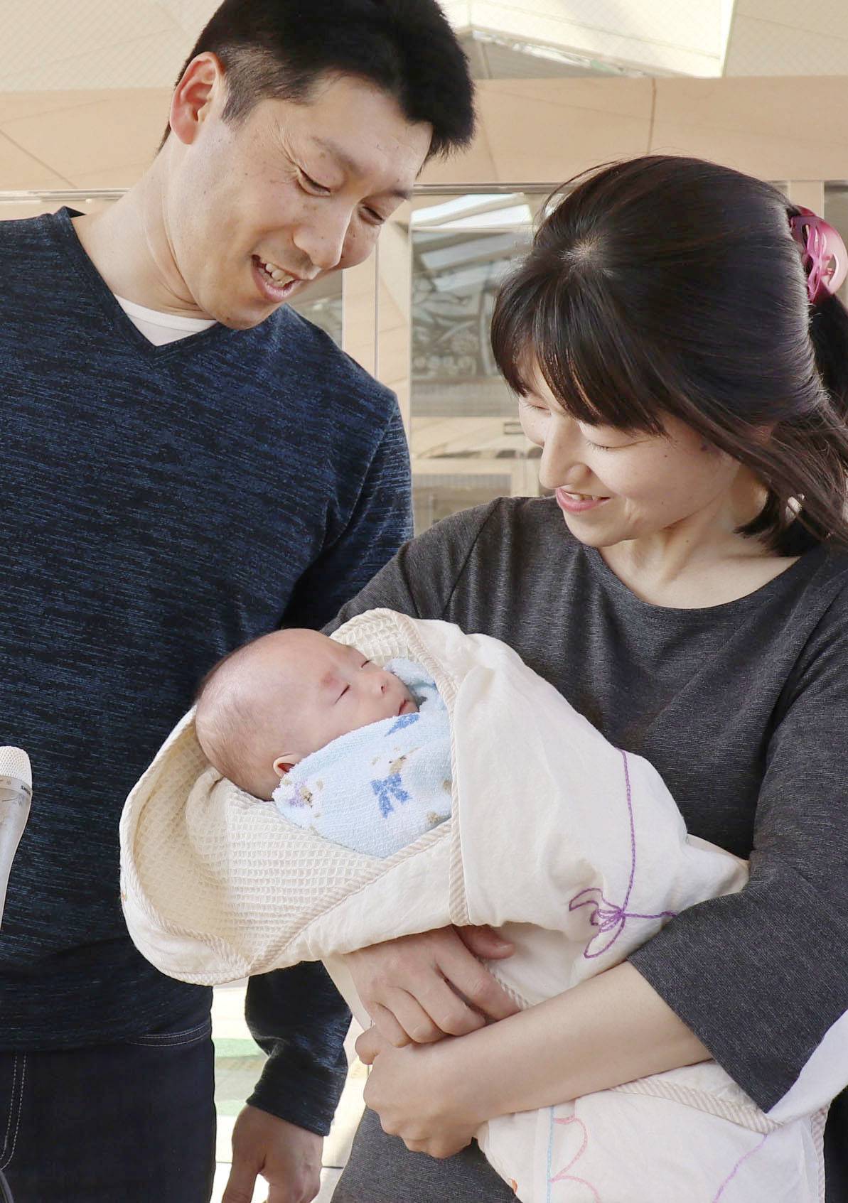 Ryusuke Sekino, a baby recognized as the world's smallest baby boy, is held in the arms of his mother Toshiko Sekino, as he is discharged from a hospital in Azumino