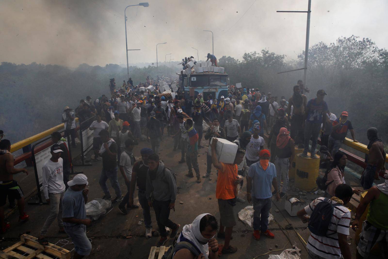 Opposition supporters unload humanitarian aid from a truck that was sent on fire in Cucuta