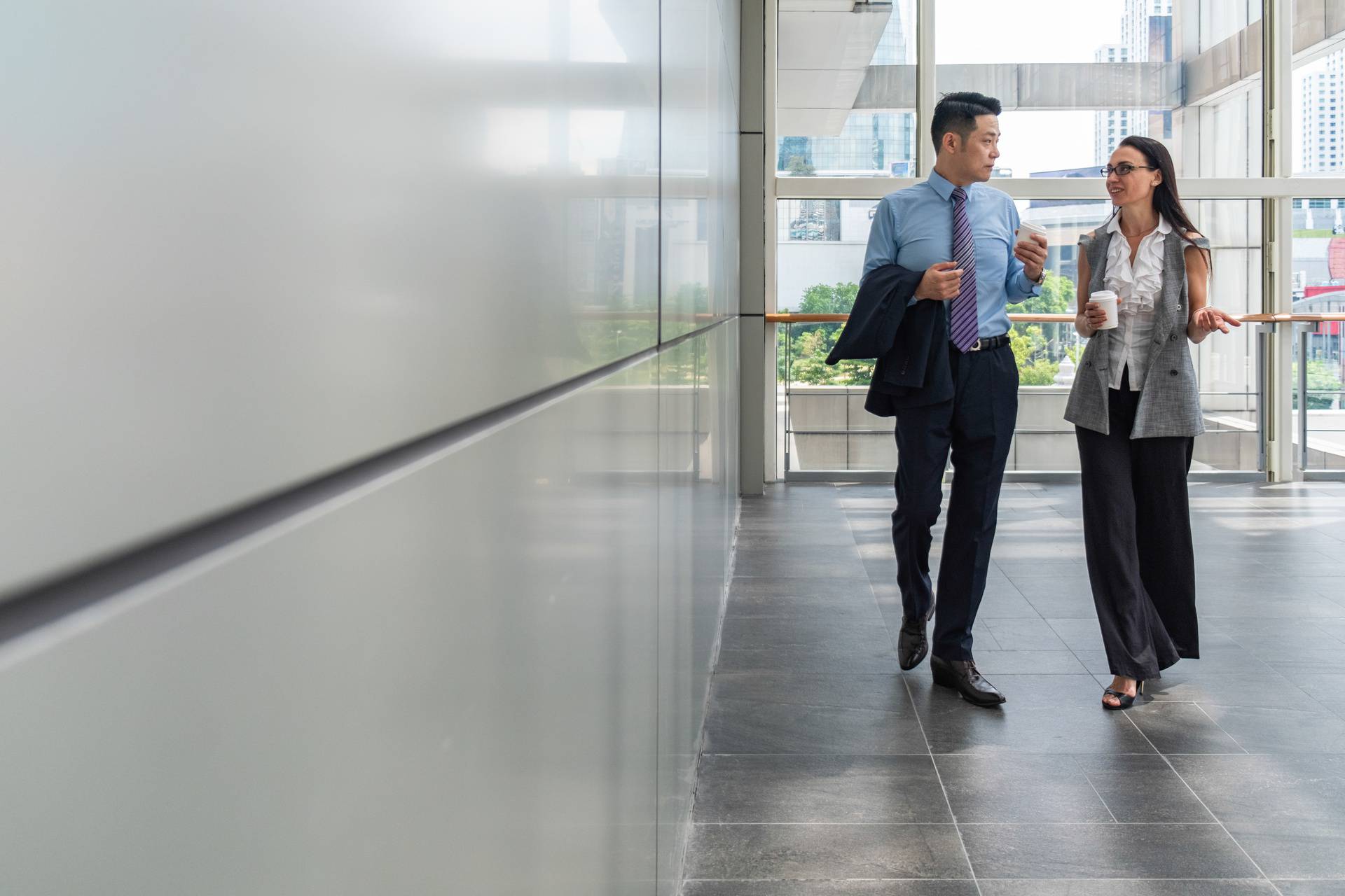 Business,People,Walking,In,Hallway,With,Big,Windows,Stock,Photo