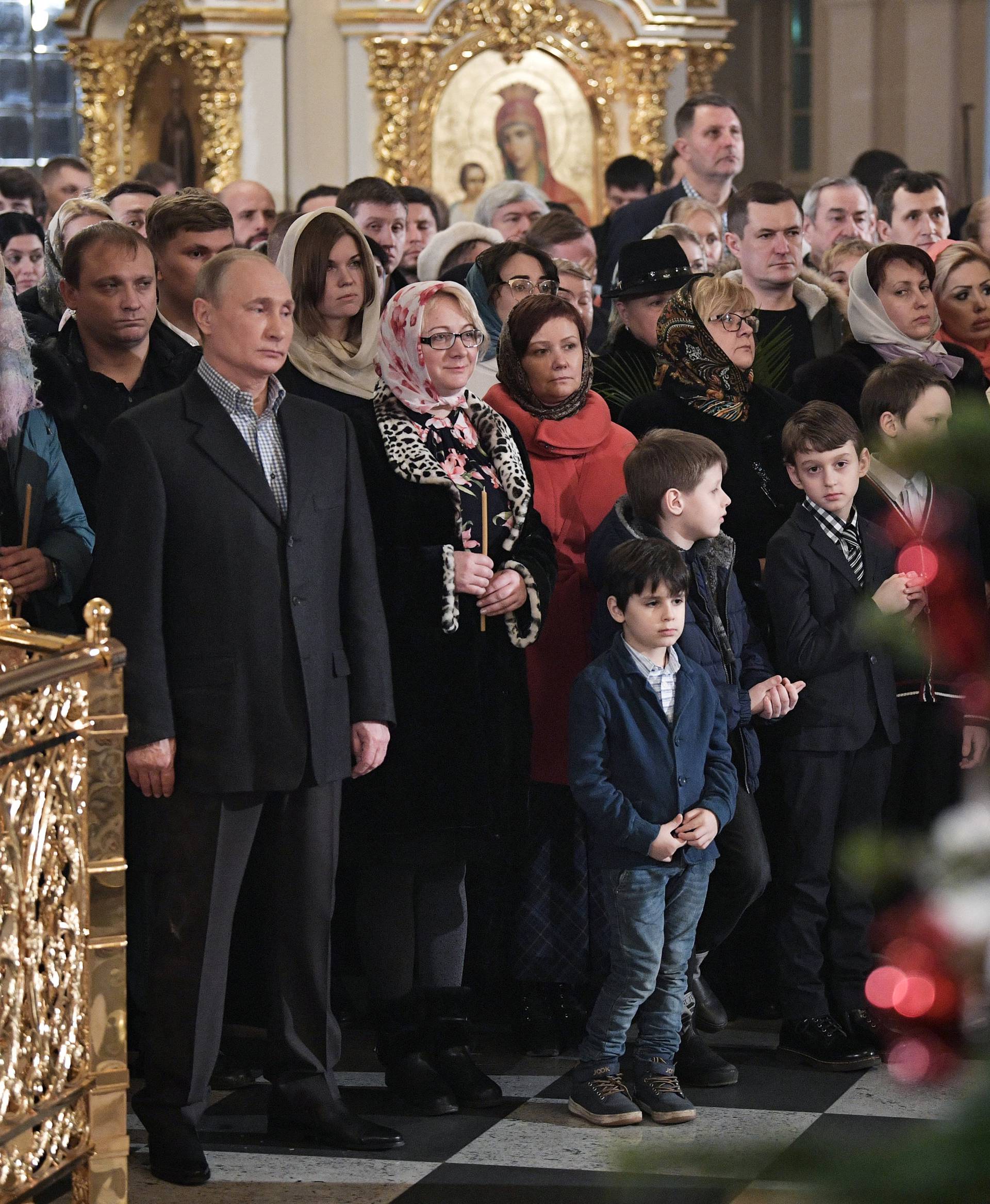 Russian President Vladimir Putin attends a service on Orthodox Christmas at the Church of Saints Simeon and Anna in St. Petersburg