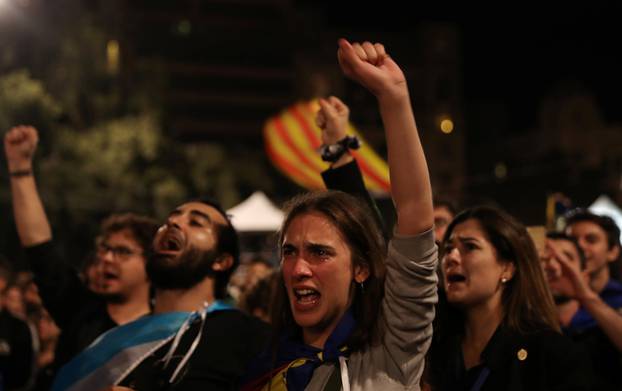 People react as they listen to Catalan president Carles Puigdemont during a gathering at Plaza Catalunya after voting ended for the banned independence referendum, in Barcelona