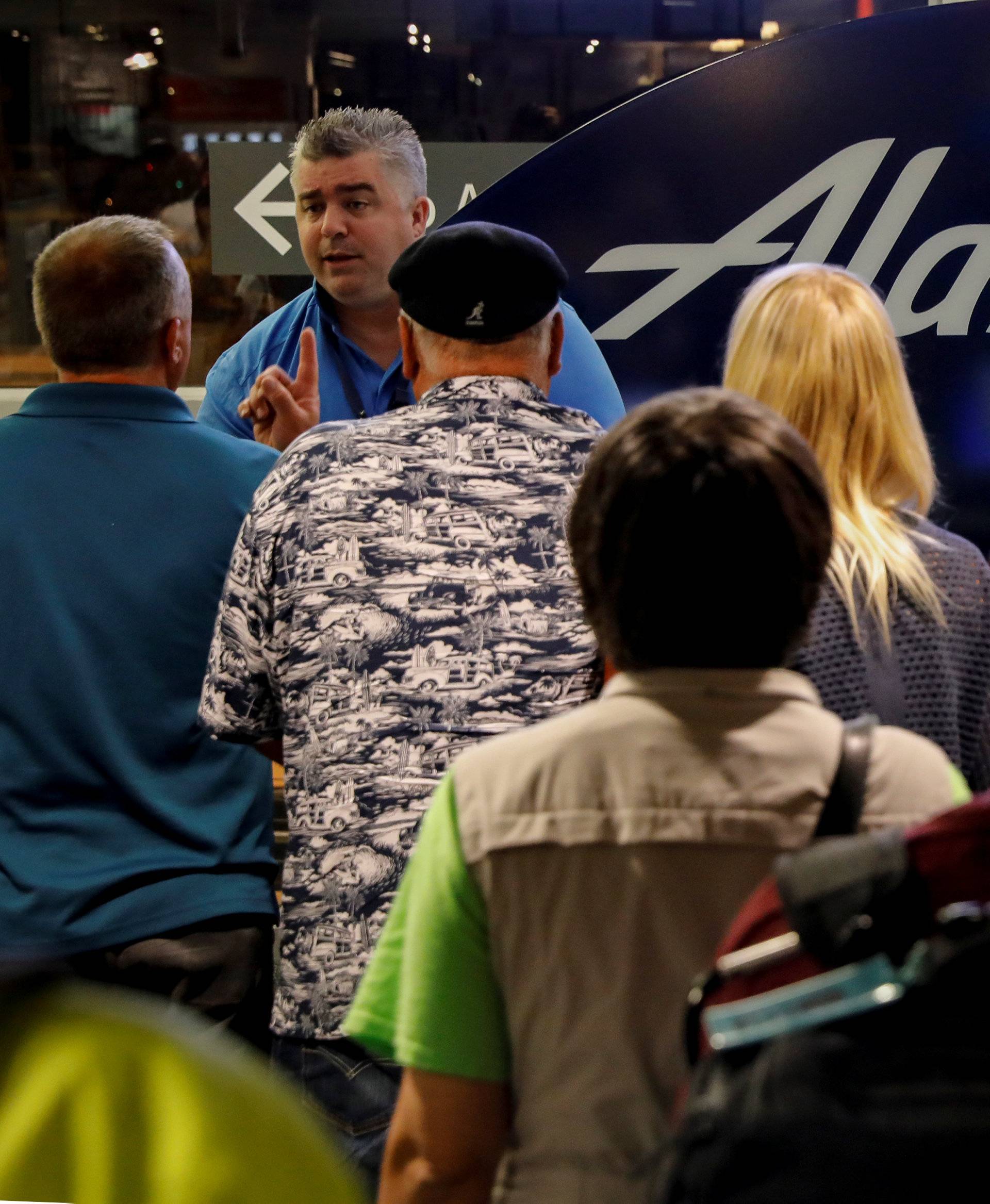 Air Alaska passengers wait in the terminal following an incident where an airline employee took off in an airplane, at Seattle-Tacoma International Airport in Seattle, Washington