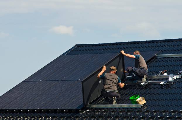 Installing,New,Black,Solar,Panels,On,The,Metal,Roof,Of