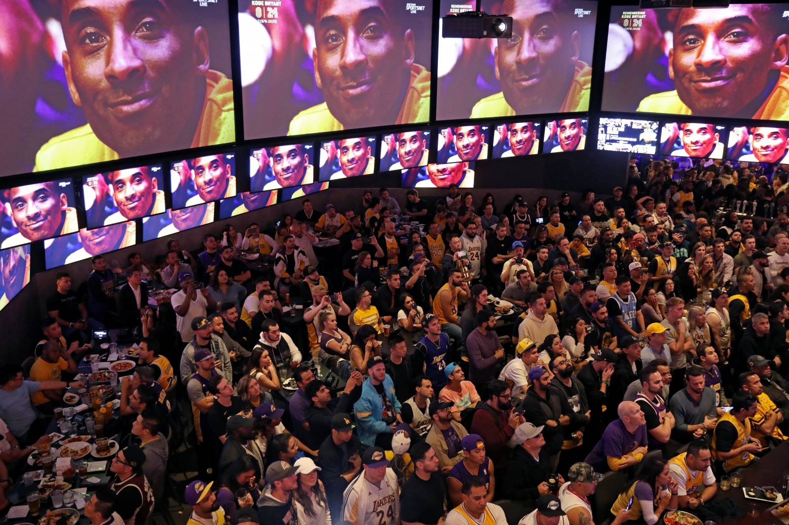 An image of Kobe Bryant appears on screens at Tom’s Watch Bar as fans watch a televised Los Angeles Lakers home game