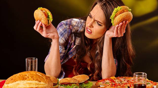 Girl eating big sandwich.