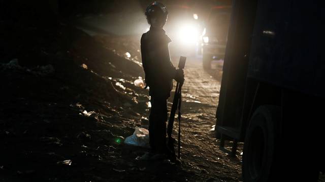 A riot policeman secures a scene of a bus blast in Giza