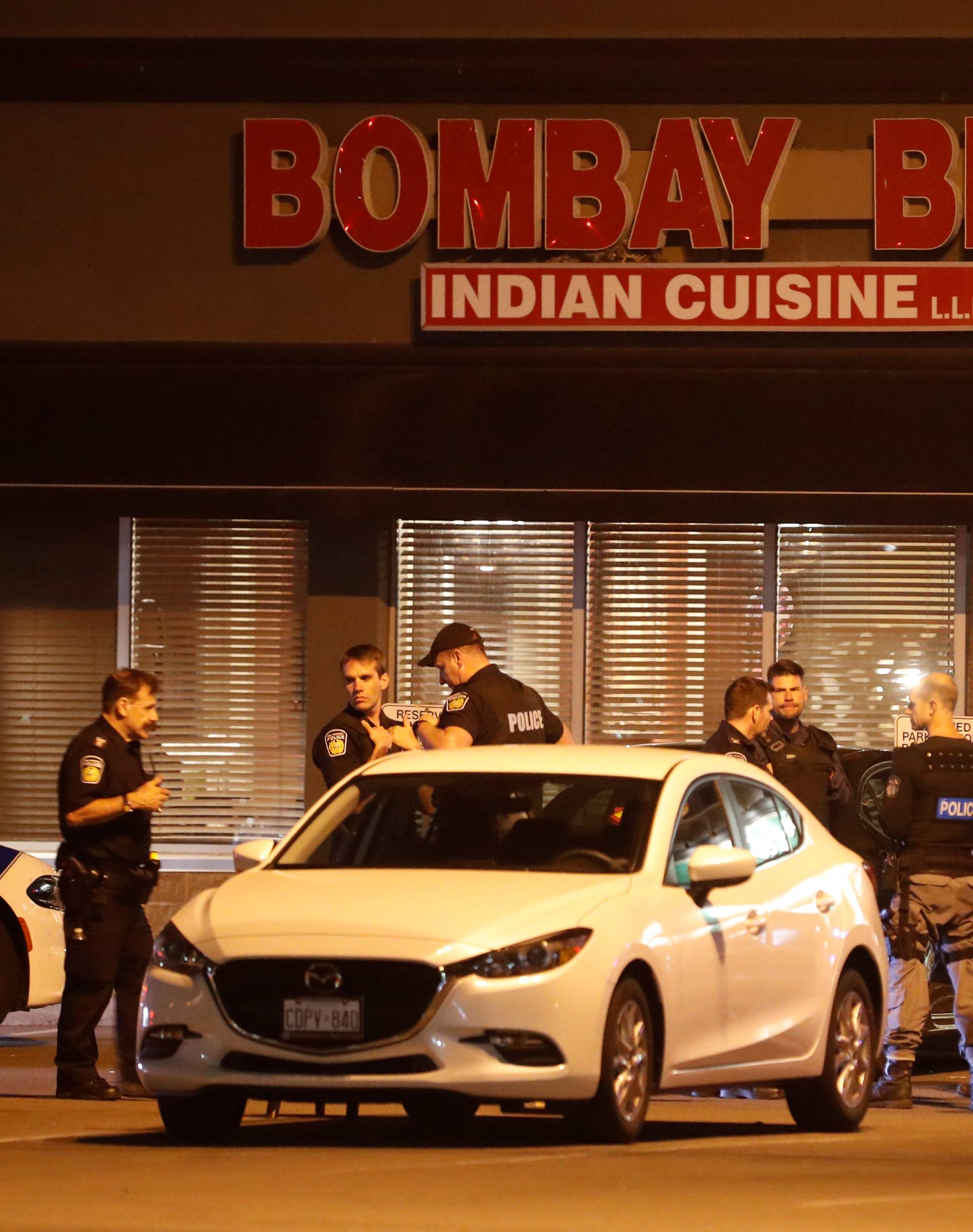 Police officers stand in front of Bombay Bhel restaurant, where two unidentified men set off a bomb, in Mississauga