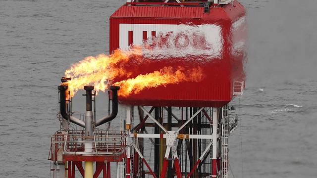 FILE PHOTO: gas torch is seen next to the Lukoil company sign at the Filanovskogo oil platform in the Caspian Sea