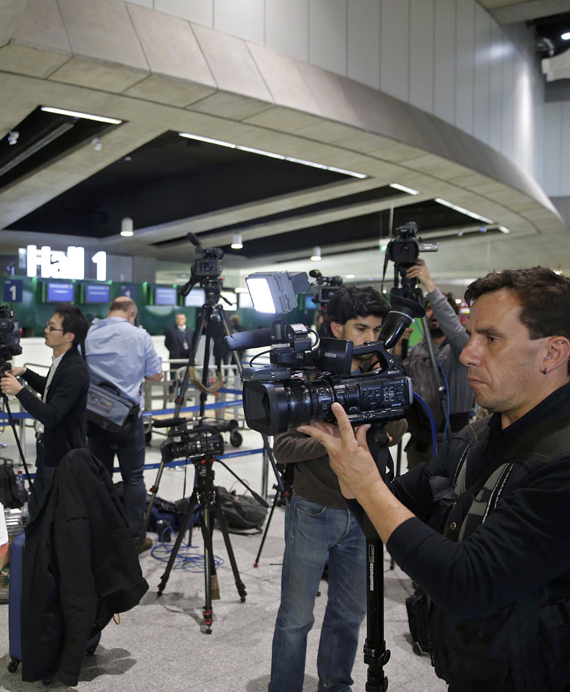 Journalists report near the EgyptAir desk at Charles de Gaulle airport in Paris