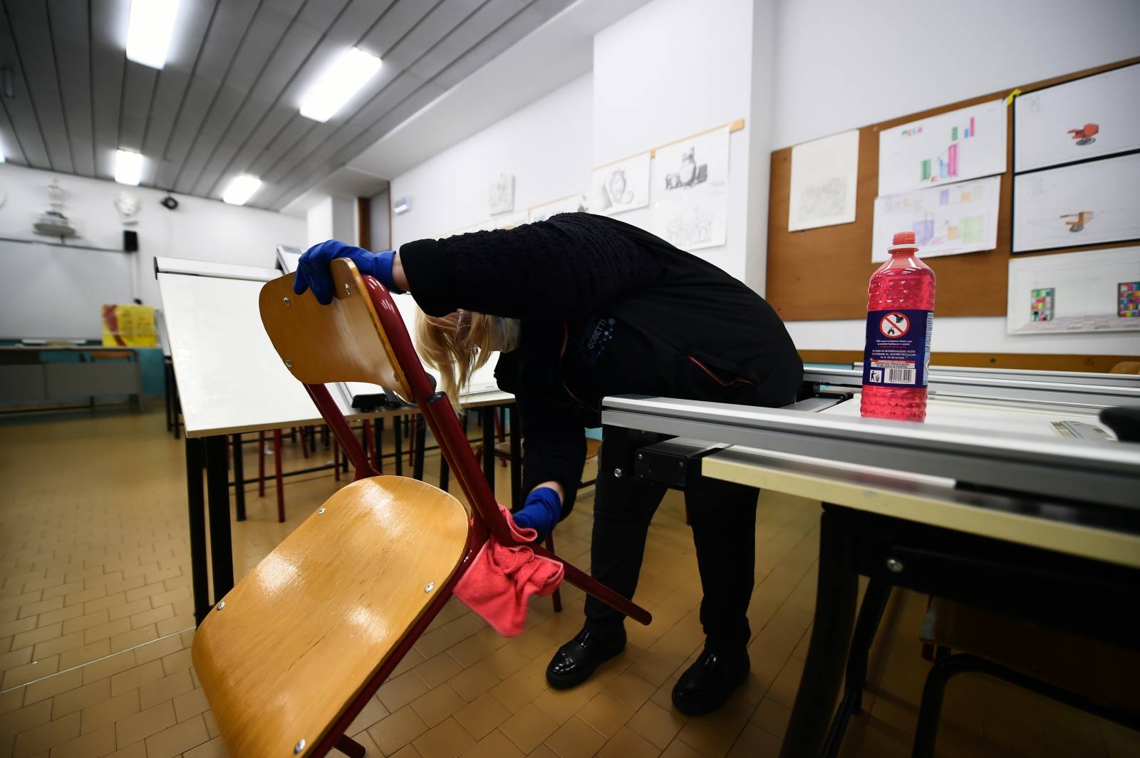 A cleaner sanitises a classroom at the Piero Gobetti high school in Turin