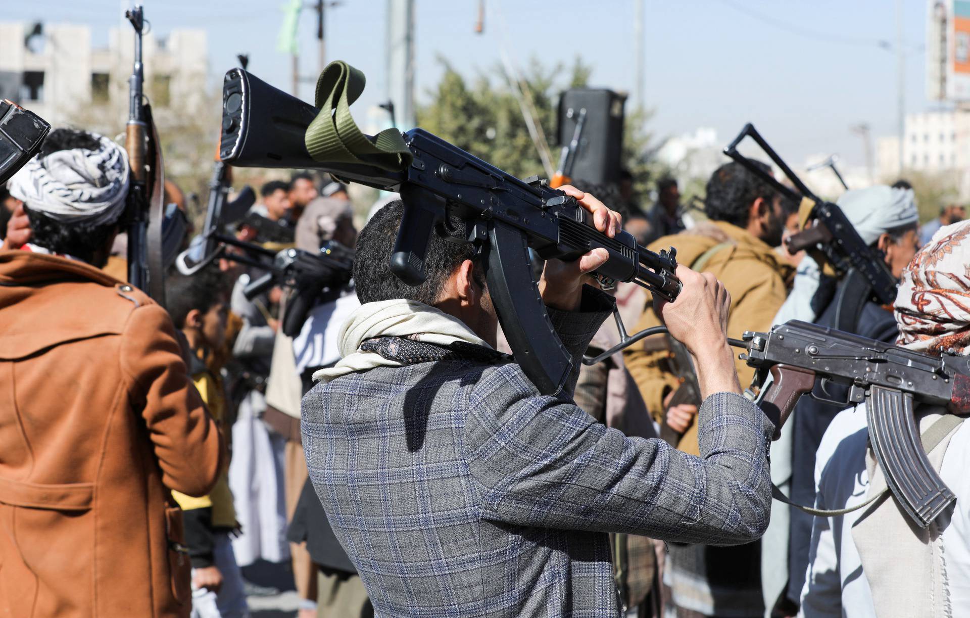 Newly recruited Houthi fighters hold up firearms during a ceremony at the end of their training in Sanaa