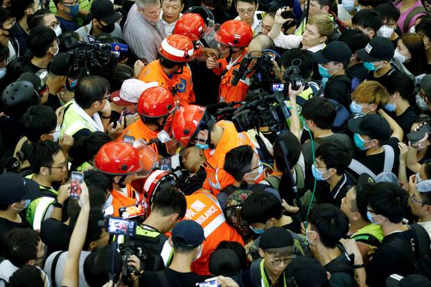 Medics attempt to remove an injured man who anti-government protesters said was an undercover policeman at the airport in Hong Kong