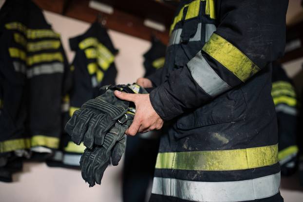 A,Closeup,Shot,Of,A,Firefighter,In,A,Uniform,Putting