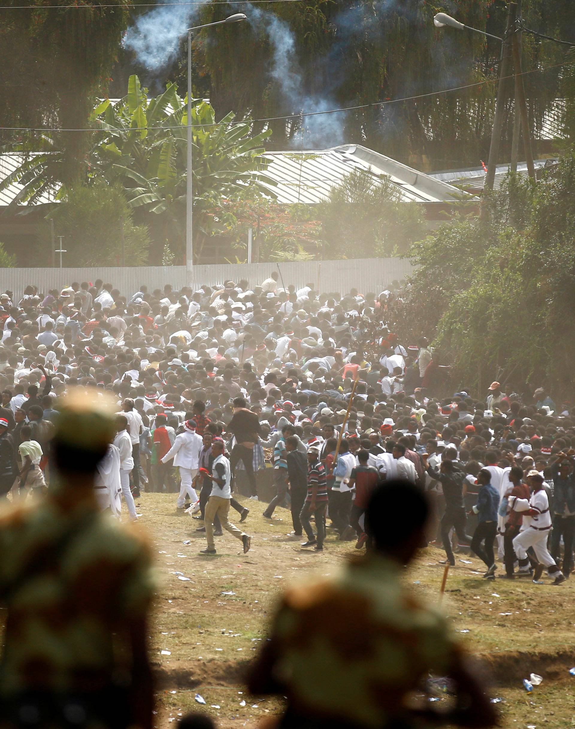 Protestors run from tear gas launched by security personnel during the Irecha, the thanks giving festival of the Oromo people in Bishoftu town of Oromia region, Ethiopia