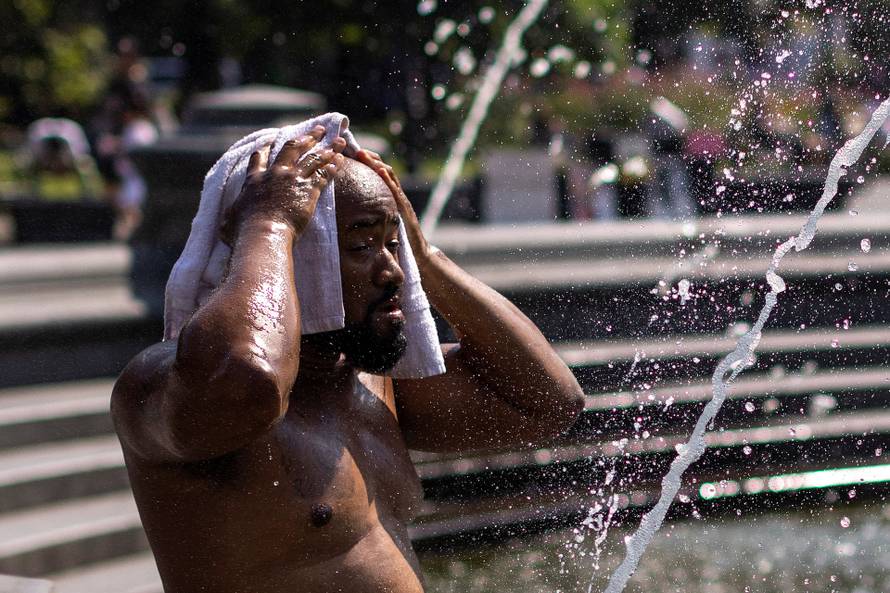 A man cools off during a hot and humid day at Washington Square park in New York City