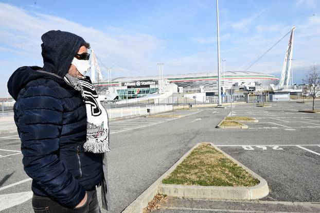 FILE PHOTO: A man wearing a face mask is seen outside the Allianz Stadium in Turin